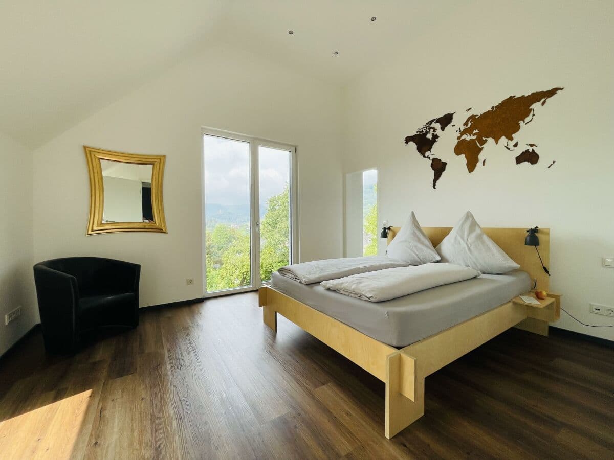 Schlafzimmer 1 mit Doppelbett und Weltkarten-Wanddeko